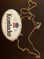 Szyld piwa Krombacher na łańcuchu widok z przodu.