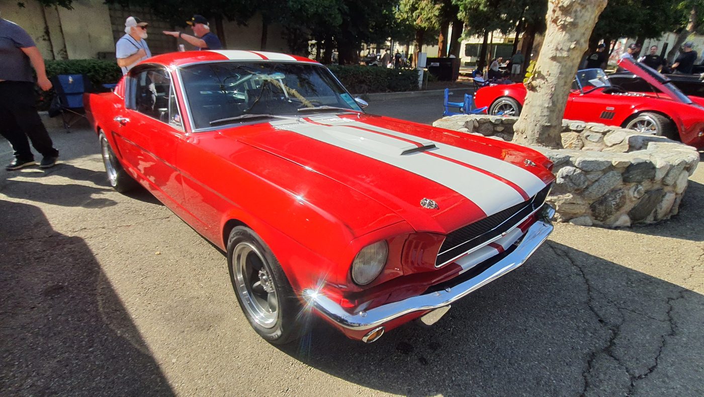 Czerwony Ford Mustang fastback 1966 w białych pasach