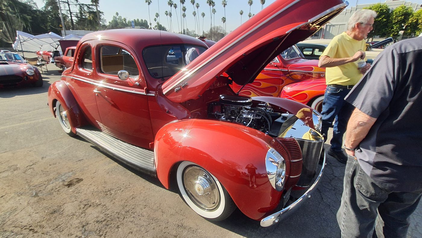 Czerwony Ford Deluxe Tudor sedan 1940 z otwartą maską