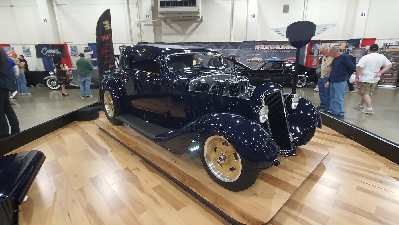 Granatowy Ford 3-window coupe 1934 na złotych felgach w hali