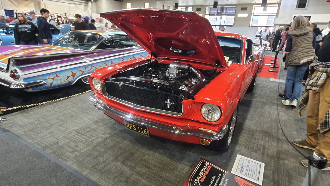 Czerwony Ford Mustang fastback 1966 z otwartą maską w hali