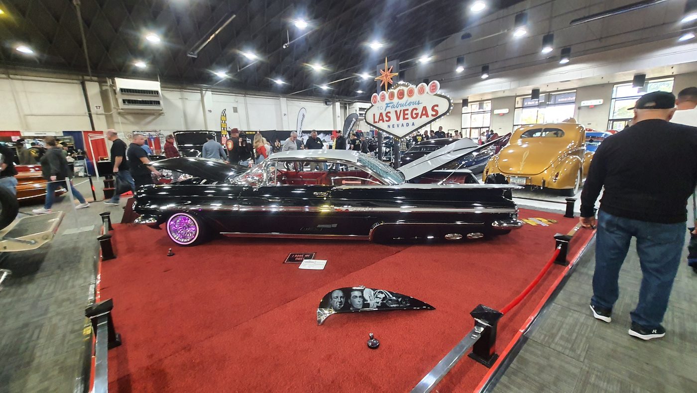 Czarny Chevrolet Impala 1958 lowrider na czerwonym dywanie