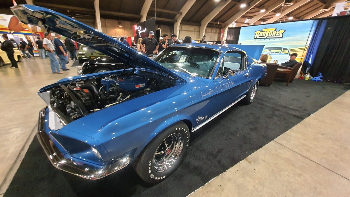 Niebieski Ford Mustang fastback 1968 z otwartą maską w hali