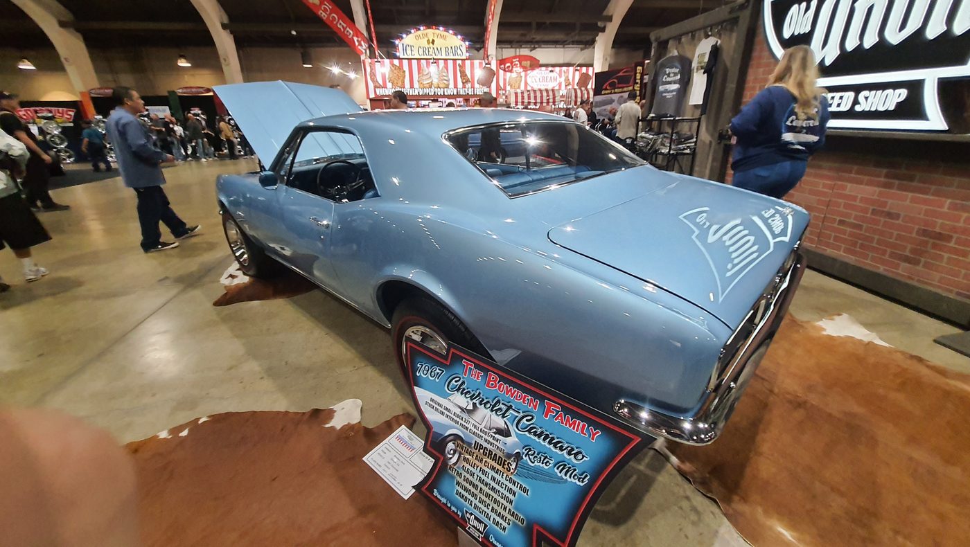 Błękitny Chevrolet Camaro 1967 z otwartą maską w hali