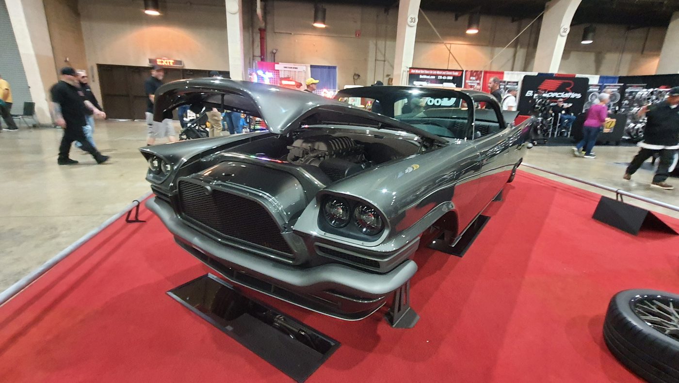 Grafitowy Chrysler 300C 1957 z otwartą maską na czerwonym dywanie