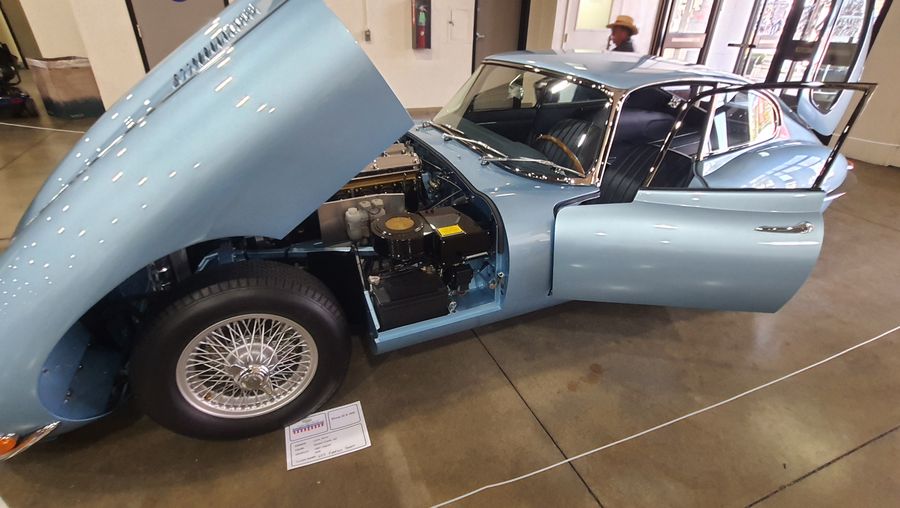 Błękitny Jaguar E-Type Series 1 coupe z otwartą maską